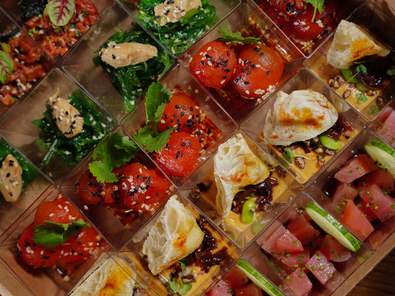A vibrant display of gourmet appetizers with fresh ingredients in individual boxes, ideal for parties.